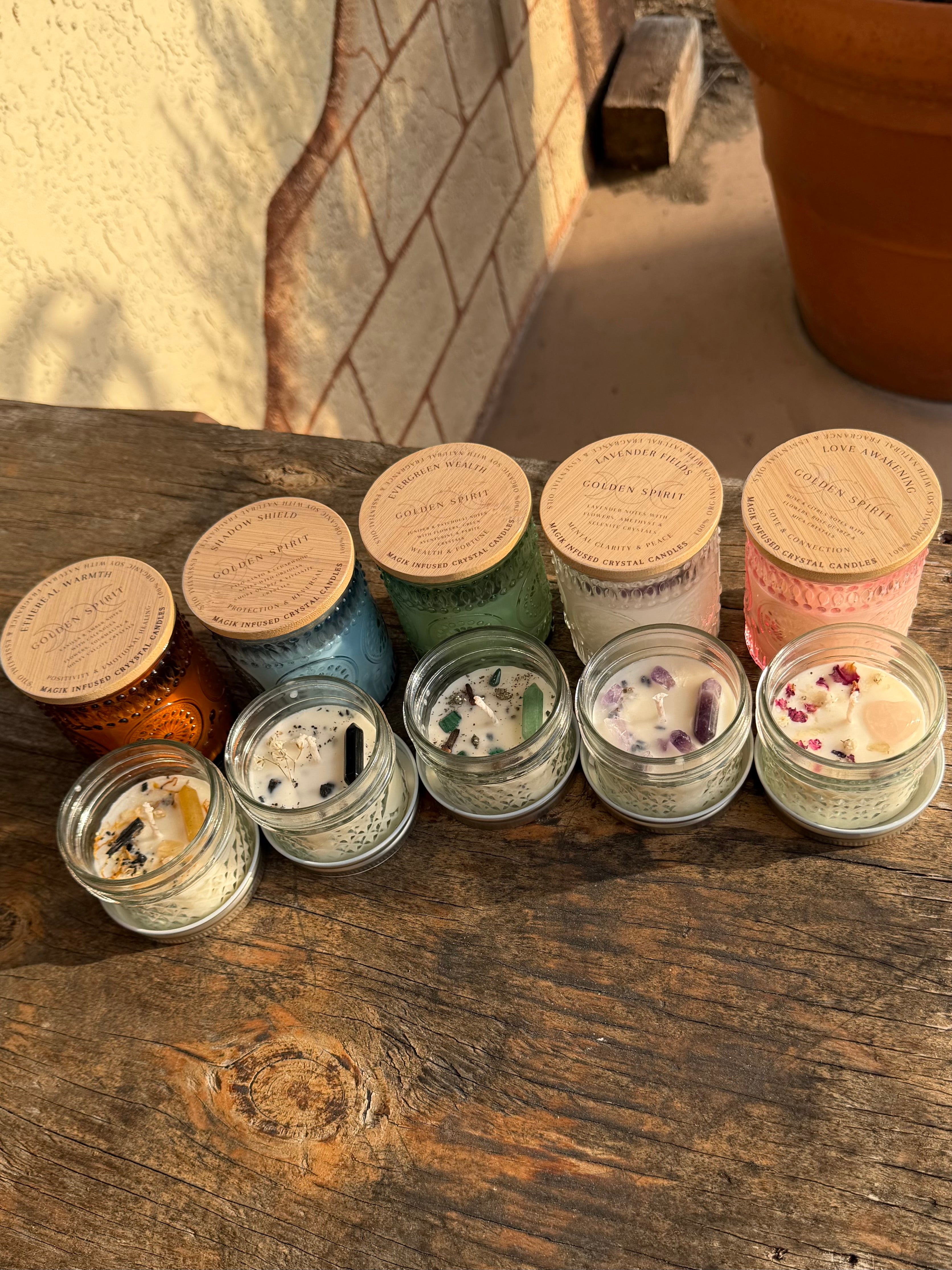 Assorted candles with visible labels on a wooden surface.
